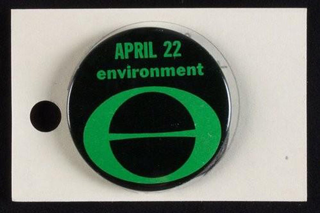 A black button with 'April 22 Environment' in green font above a symbol of a circle with a line through it.