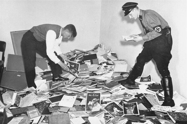 A uniformed member of the Nazi SA and a student of the Academy of Physical Exercise examine materials plundered from the library of Dr. Magnus Hirschfeld, director of the Institute for Sexual Science in Berlin on May 6, 1933.