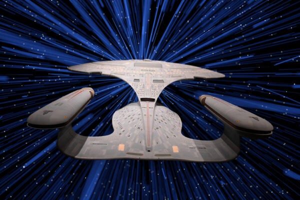 An illustration of Star Trek's USS Enterprise in warp drive