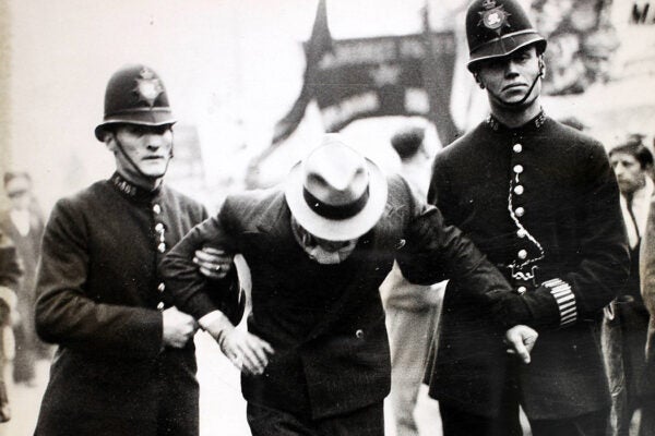 Black and white photograph of a man being arrested by the police.