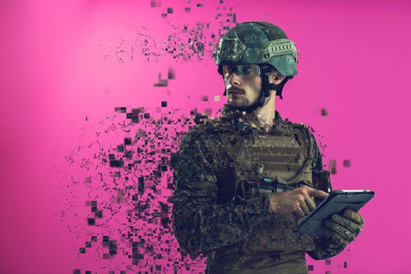 soldier using tablet computer hands closeup pnk background pixelated neural network concept