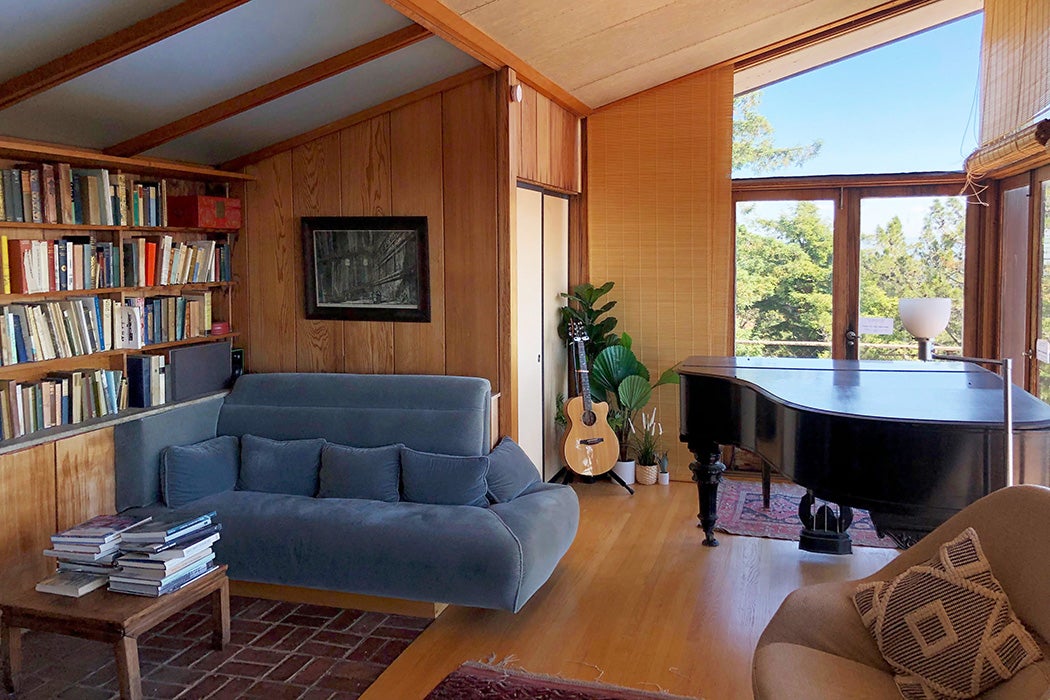 In the Weston Havens House in Berkeley, California, this is the living room / music room with an original built-in couch and a large bookshelf in the wall.