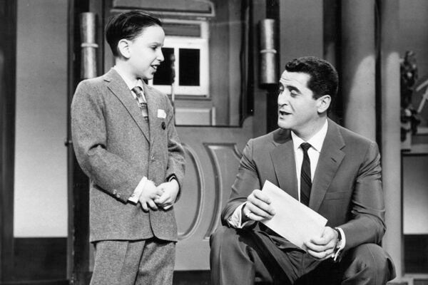 Boy genius Robert Strom is interviewed by host Hal March from the television series 'The $64,000 Question', 1955.