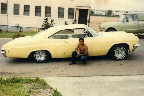 Chicano Brothers Car Club: Photograph of David Aguilar with a 1950 Chevrolet