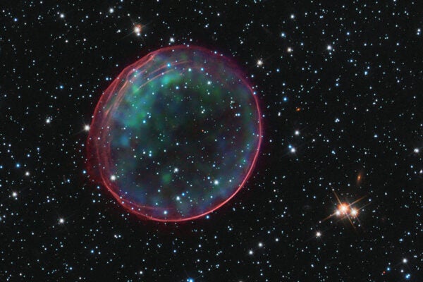 This composite image contains X-ray data from Chandra (green and blue) that show heated material in the center of a shell generated by a supernova explosion. Optical data from Hubble show the glowing pink rim, which is ambient gas being shocked by the blast wave from the supernova, as well as the surrounding star field. The Type Ia supernova that resulted in the creation of this remnant would have been visible from Earth some 400 years ago.