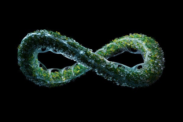 Digital generated image of organic structured infinity sign made out of transparent plastic and grass growing inside against black background.