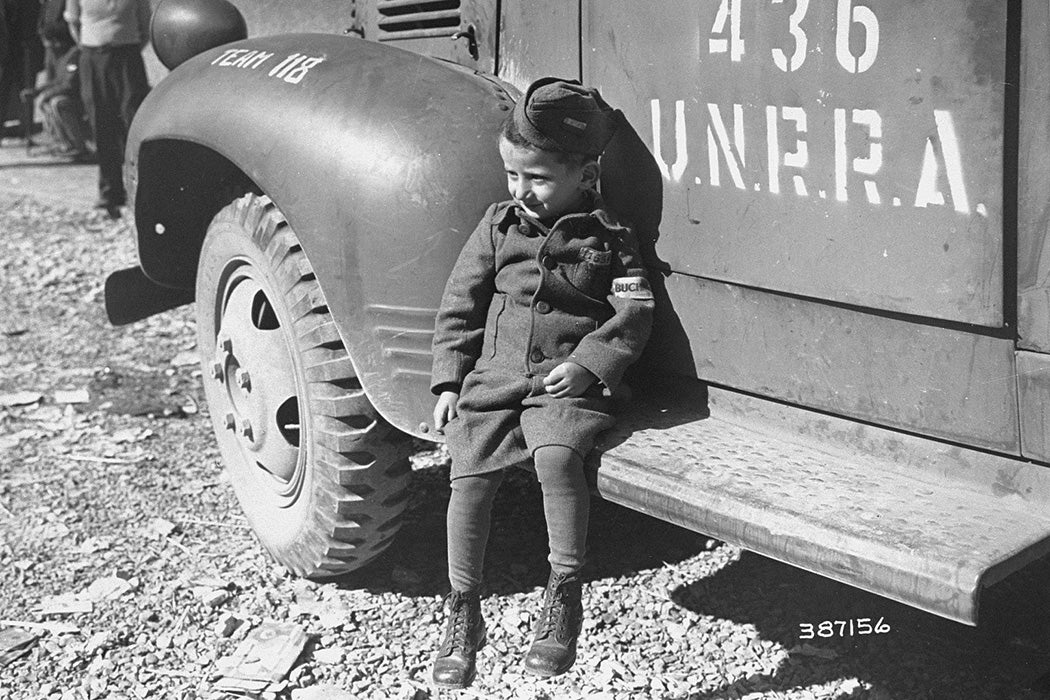 Joseph Schleifstein, a four-year-old survivor of Buchenwald, sits on the running board of an UNRRA truck soon after the liberation of the camp.