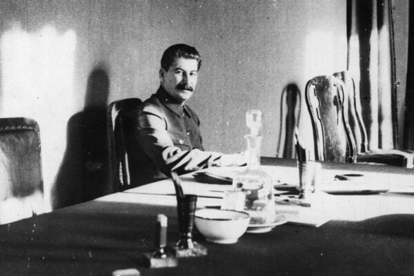 Soviet political leader Joseph Stalin (1879 - 1953) at work in his office, with a portrait of Karl Marx hanging on the wall over his head, April 1932.