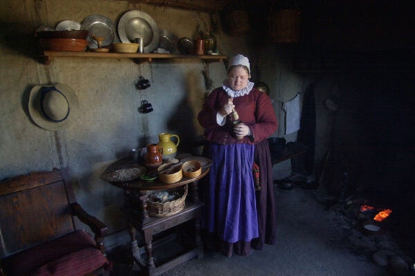 Asia Poppers, who portrays colonist Tryphosa Tracy, prepares fritters in her one-room house November 25, 2003 at Plimoth Plantation in Plymouth, Massachusetts.