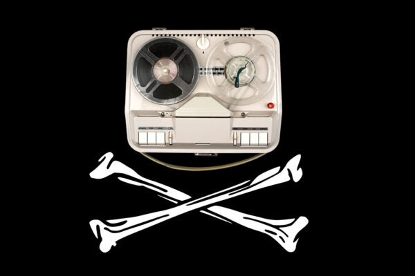 A vintage reel tape recorder on a pirate flag