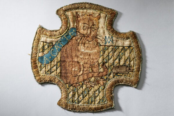 Embroidery of a ginger cat with a mouse on a chequered floor made by Mary, Queen of Scots