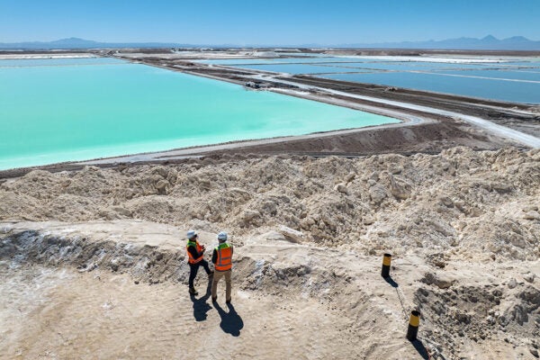 visitors stand atop a large mound of salt bi-product from lithium production at a mine in the Atacama Desert on August 24, 2022 in Salar de Atacama, Chile.