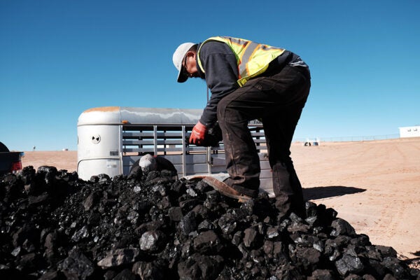 A Navajo Nation volunteer collects coal to distribute to Native Americans in need at a free wood collection site on December 17, 2021 in Tuba City, Arizona.