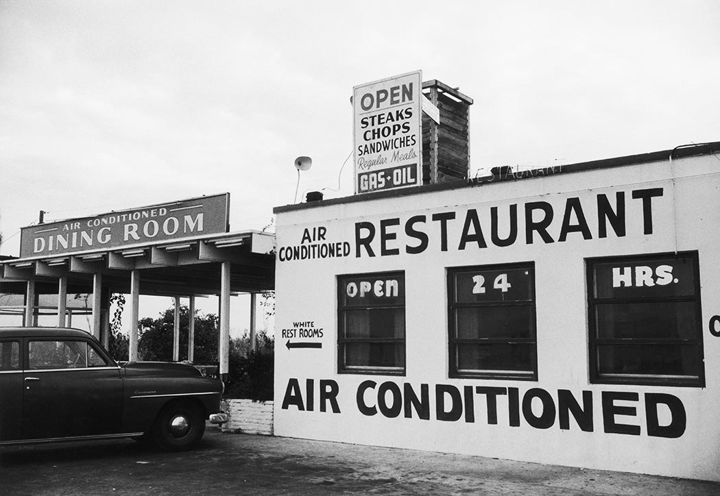 A sign outside an air conditioned American restaurant points to the 'White Rest Rooms', in a clear indication of racial segregation, circa 1960.