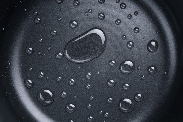 A Pattern of Various Shaped Water Drops on A teflon Frying Pan