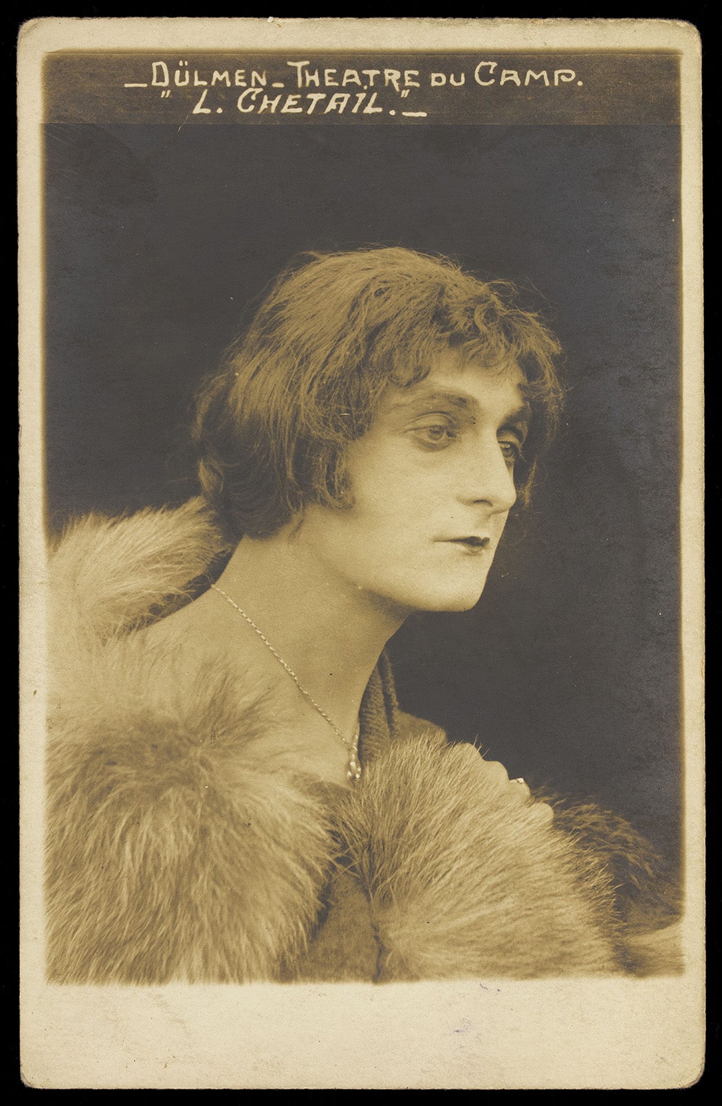 A French prisoner of war in drag acting in an internment camp in Dülmen. Photographic postcard, ca. 1917.