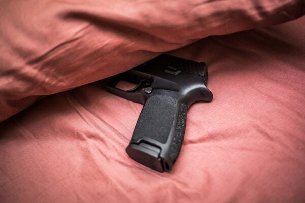 A gun partially hidden by a pillow