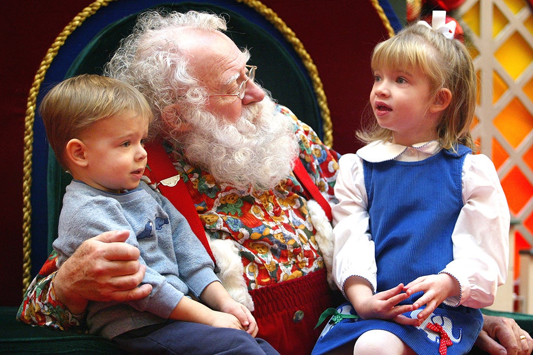 Sporting a natural white beard, Santa Claus visits with Ian, 2, and sister Devin Rachiele, 4, December 19, 2003 at Golf Mill Mall in Niles, Illinois.