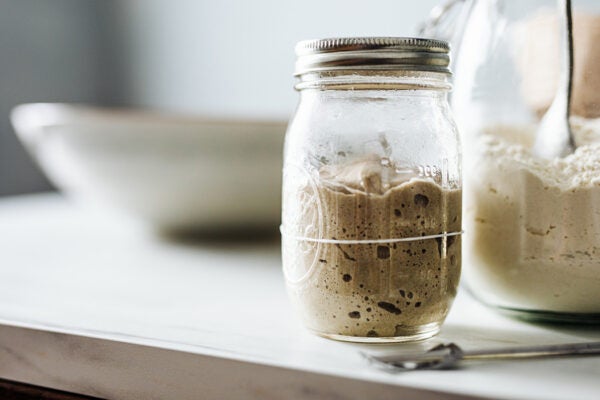 Close-up of sourdough starter and flour in jars