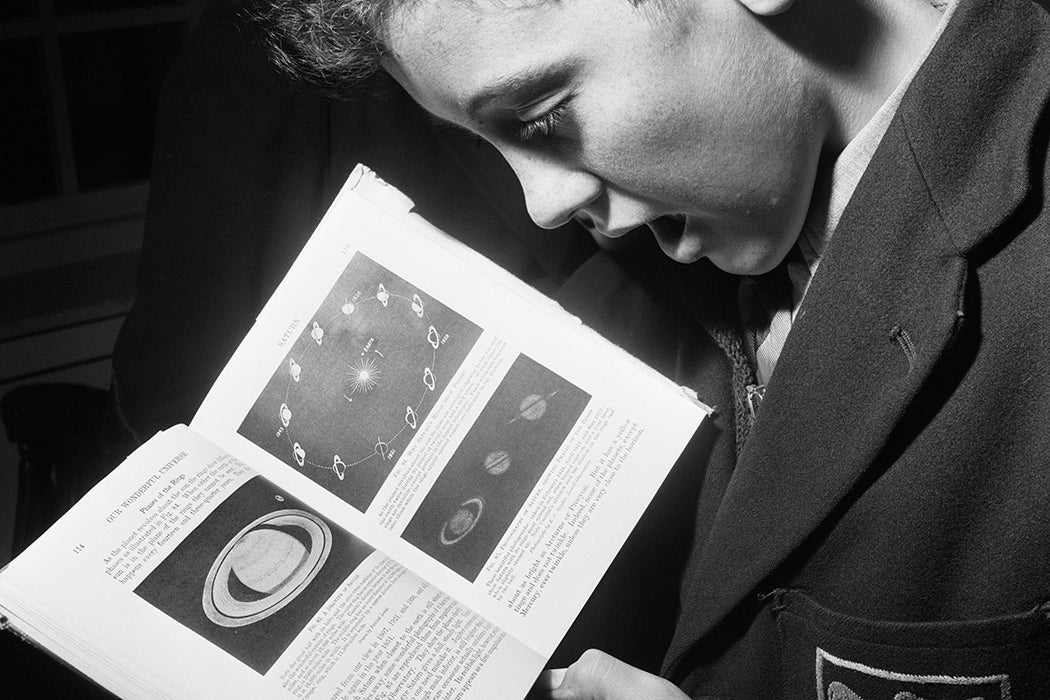 A child reading about the phases and rings of Saturn