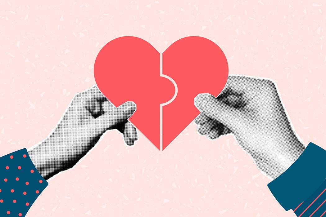 male and female hands holding puzzles in the shape of heart halves.