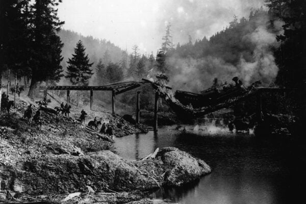 A bridge spanning a river collapses beneath the passage of a train, in a scene from the United Artists film 'The General', directed by and starring Buster Keaton, 1927