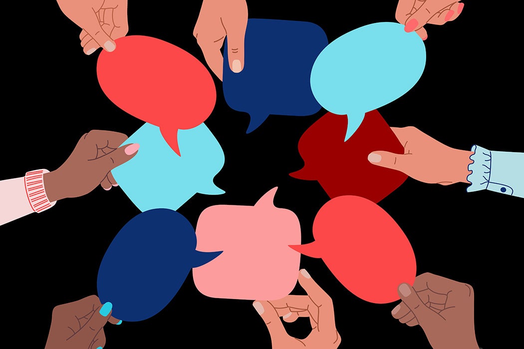 Diverse human hands holding speech bubbles.