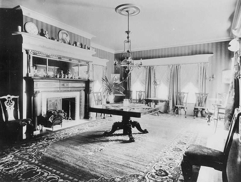 Dining room of the Hord residence with hanging light fixtures, a fireplace, and period furniture. Click on the image to take a closer look.