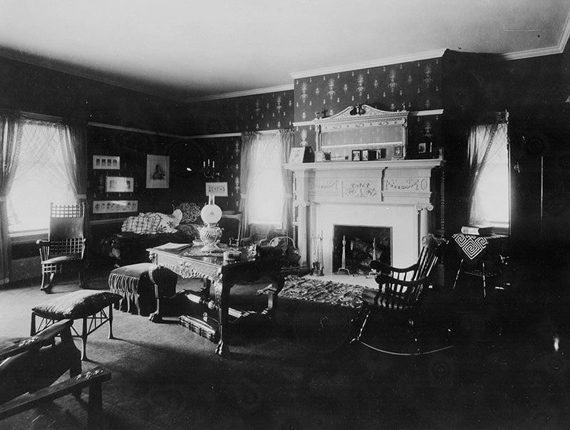 Sitting room in the Hord residence with a daybed, rocking chairs, patterned wall paper, and Adams style fireplace. Click on the image to take a closer look.