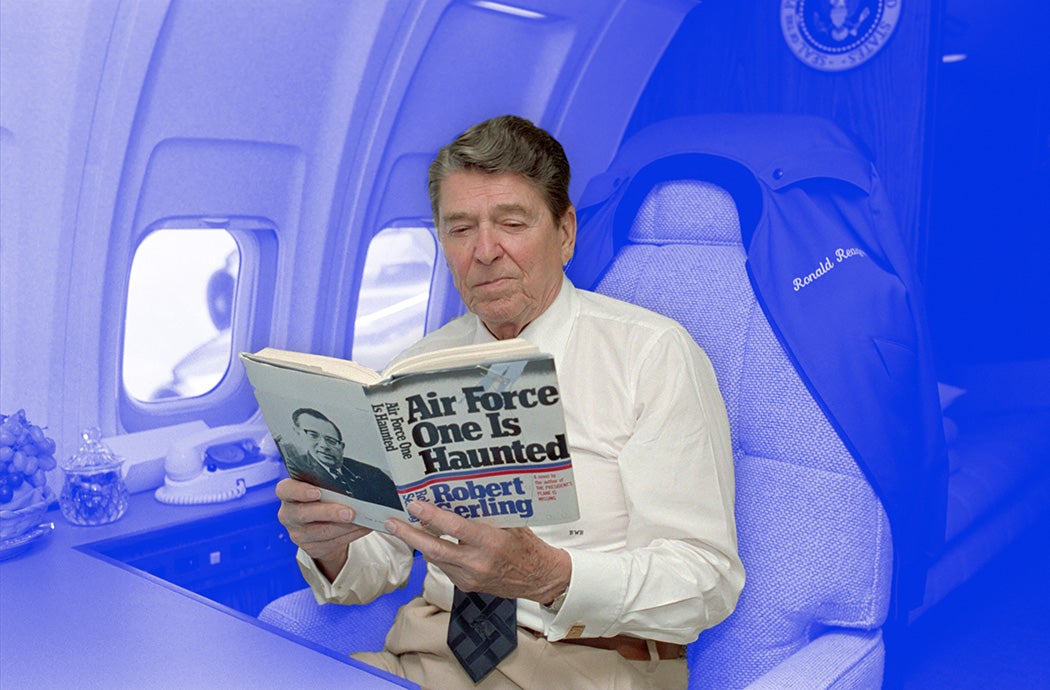 President Reagan reading "Air Force One is Haunted" aboard Air Force One, 1986.