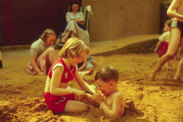 Children playing in the sand-pit at the Oasis swimming pool, London, 1956