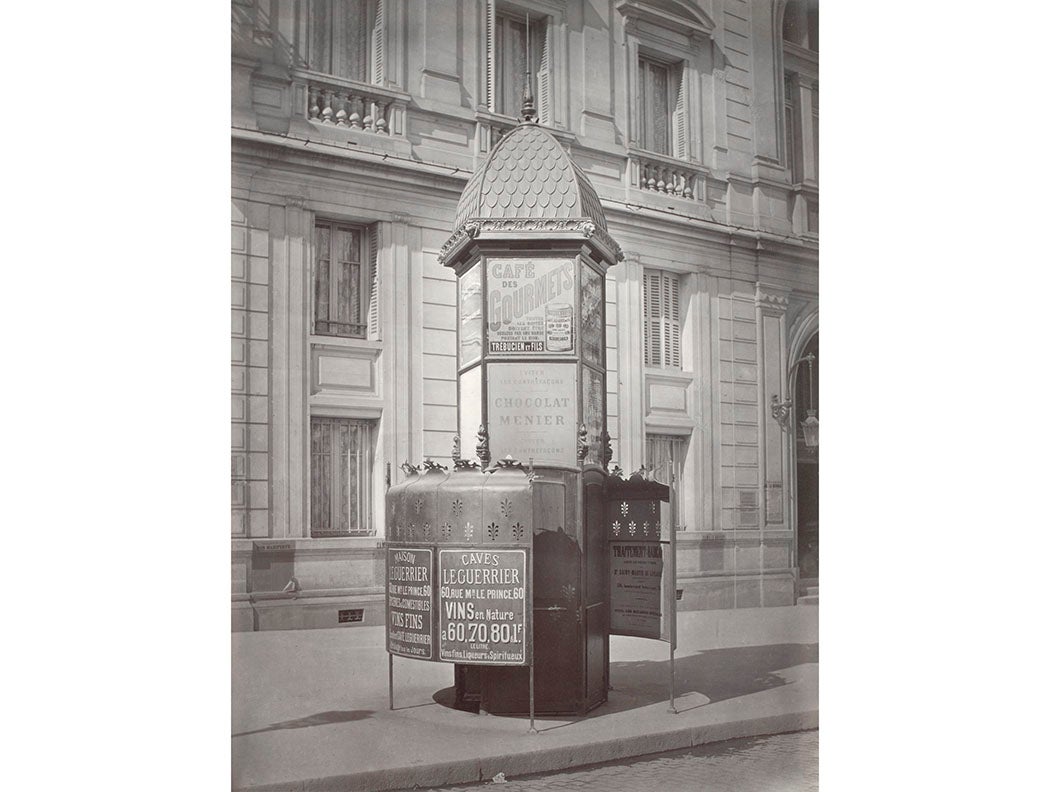 Cast iron urinal on curb of street, advertising on panels of urinal walls, Paris, circa 1865