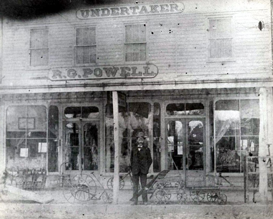 R.G. Powell Undertaker storefront with proprietor
