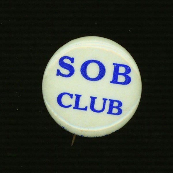"S O B Club" white button with blue lettering.