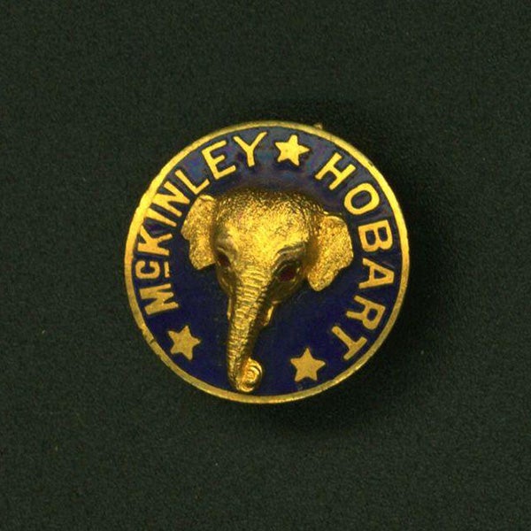 "McKinley / Hobart" gold and blue button with raised elephant head motif.